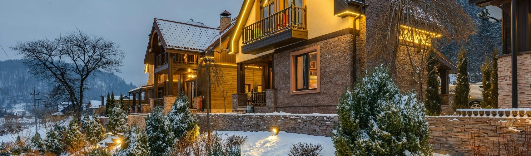 Exterior of luxurious cabin-style home during nighttime in winter